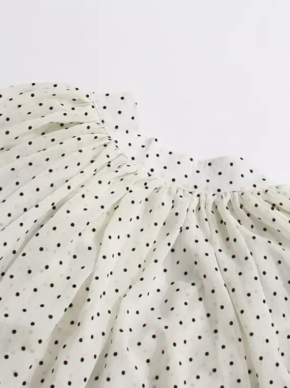 Blouse blanche pour femme col en V manches longues lacées et à volants.