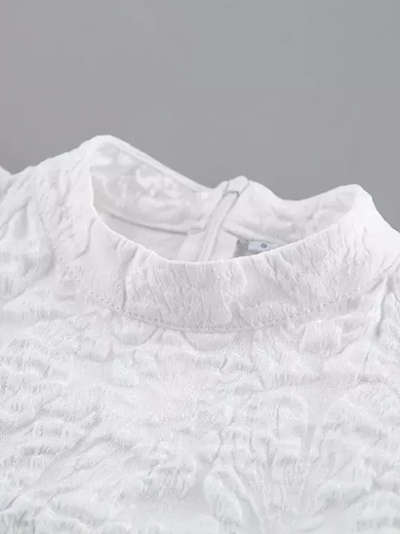 Blouse texturée en jacquard à manches bouffantes col montant taille péplum ourlet évasé