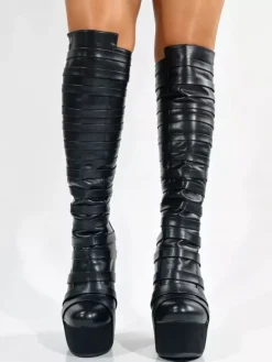 Bottes noires montantes à plateforme pour femmes à brides et fermeture éclair à talon compensé.