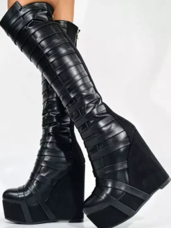 Bottes noires montantes à plateforme pour femmes à brides et fermeture éclair à talon compensé.