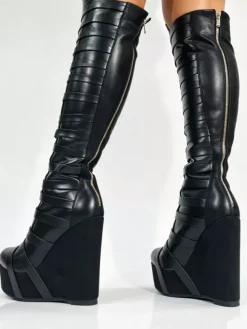 Bottes noires montantes à plateforme pour femmes à brides et fermeture éclair à talon compensé.