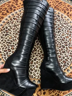 Bottes noires montantes à plateforme pour femmes à brides et fermeture éclair à talon compensé.