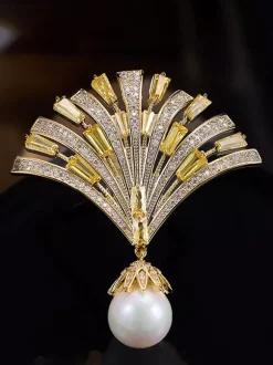 Broche pendentif en forme d'éventail ornée d'un zircon baguette et d'une grande perle.