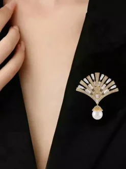 Broche pendentif en forme d'éventail ornée d'un zircon baguette et d'une grande perle.