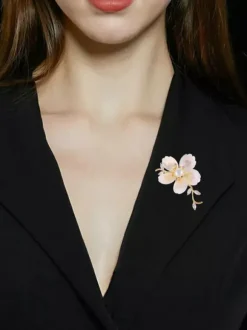 Broche branche de fleur en nacre blanche plaquée or et ornée de zirconiums cubiques