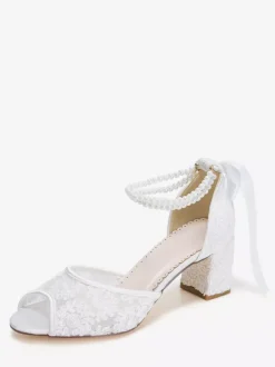 Chaussures de mariée en dentelle à bout ouvert ornées de fleurs de perles et de talons épais.