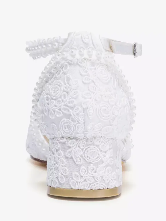 Chaussures de mariée ivoire à bout pointu talon compensé et bride cheville ornées de dentelle.