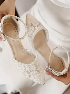 Chaussures de mariée ivoire à bout pointu talon compensé et bride cheville ornées de dentelle.