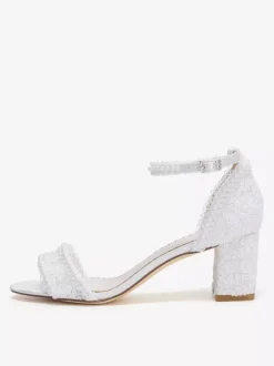 Chaussures de mariée ivoire à bout ouvert et talon compensé ornées de dentelle.