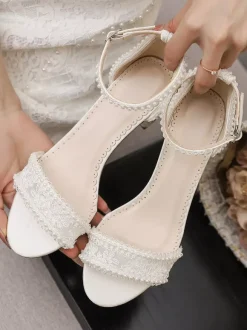 Chaussures de mariée ivoire à bout ouvert et talon compensé ornées de dentelle.
