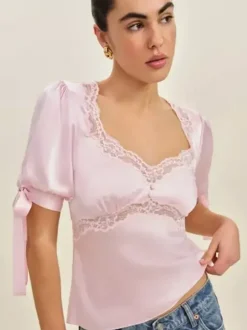 Chemisier en satin à col V bouffant et manches courtes bouffantes orné de dentelle avec ceinture à nouer dans le dos et coupe ajustée. Élégante chemise pour femme.