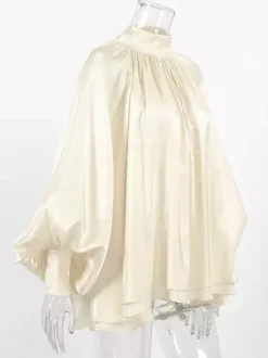 Chemisier oversize en satin crème brillant à col montant froncé manches ballon et poignets perlés