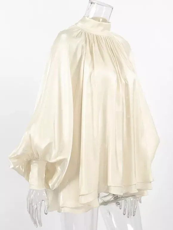 Chemisier oversize en satin crème brillant à col montant froncé manches ballon et poignets perlés