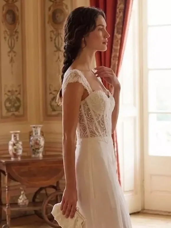 Combinaison de mariée en dentelle appliquée longue jusqu'au sol décolleté travaillé manches courtes taille naturelle couleur ivoire