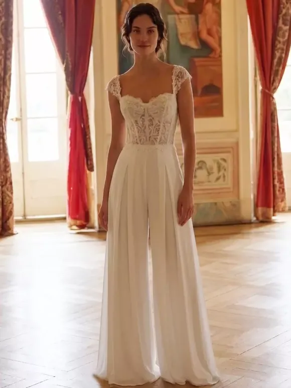 Combinaison de mariée en dentelle appliquée longue jusqu'au sol décolleté travaillé manches courtes taille naturelle couleur ivoire