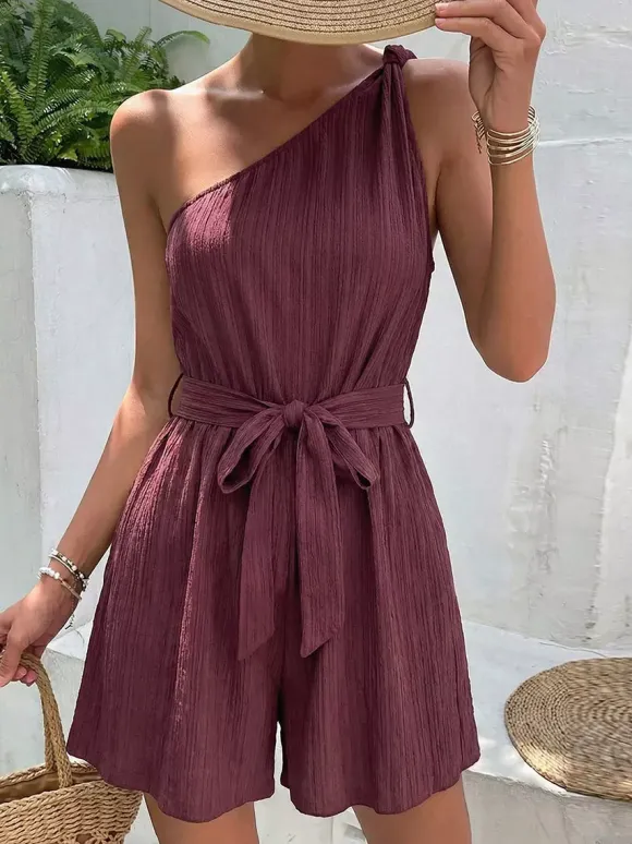 Combinaison-short d'été décontractée pour femme mauve asymétrique avec ceinture et tissu texturé à nouer à la taille.