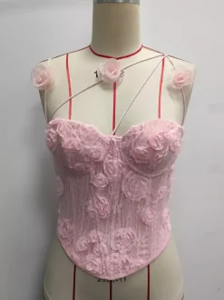 Corsets blancs sexy sans manches à bretelles et décolleté ajusté ornés de fleurs.