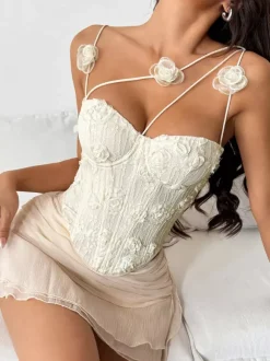 Corsets blancs sexy sans manches à bretelles et décolleté ajusté ornés de fleurs.