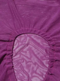 Crop top violet à col montant et manches longues à découpes apparentes.