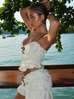 Ensemble deux pièces abricot chic plissé idéal pour les vacances avec bretelles et col à volants jupe sans manches à volants.