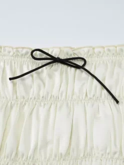 Ensemble deux pièces abricot chic plissé idéal pour les vacances avec bretelles et col à volants jupe sans manches à volants.