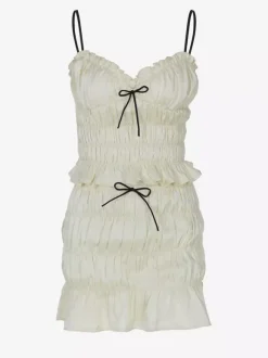 Ensemble deux pièces abricot chic plissé idéal pour les vacances avec bretelles et col à volants jupe sans manches à volants.