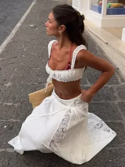 Ensemble deux pièces blanc décontracté avec jupe sans manches sculptante et découpes idéal pour la plage.