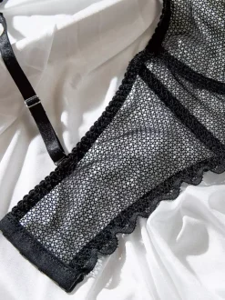 Ensemble soutien-gorge et culotte deux pièces noirs à volants en résille orné de motifs.
