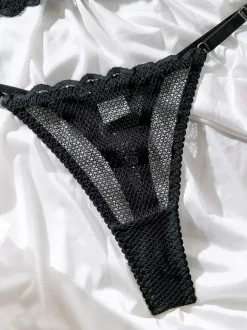 Ensemble soutien-gorge et culotte deux pièces noirs à volants en résille orné de motifs.