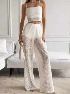 Ensemble deux pièces en dentelle florale blanche : haut court à fines bretelles et pantalon large transparent.