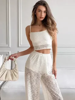 Ensemble deux pièces en dentelle florale blanche : haut court à fines bretelles et pantalon large transparent.