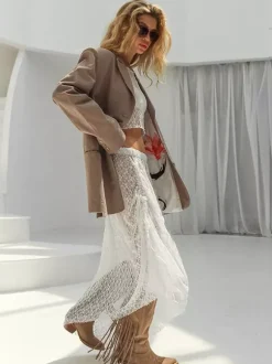 Ensemble deux pièces en dentelle transparente pour femme : haut court à manches longues et jupe maxi asymétrique.