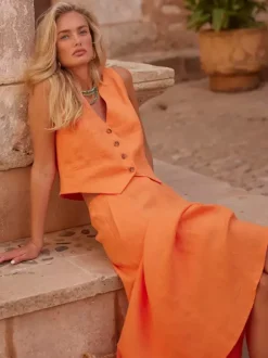 Ensemble deux pièces jupe et haut orange à boutons rétro style resort en lin col V sans manches.