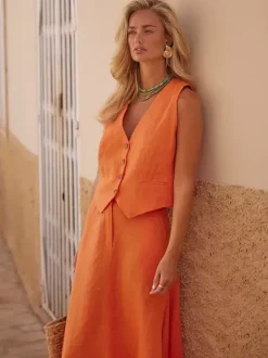 Ensemble deux pièces jupe et haut orange à boutons rétro style resort en lin col V sans manches.