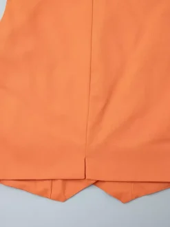 Ensemble deux pièces jupe et haut orange à boutons rétro style resort en lin col V sans manches.