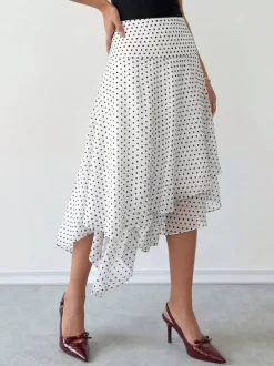 Jupe midi blanche à petits pois taille haute ourlet asymétrique à volants irréguliers en mousseline fluide.