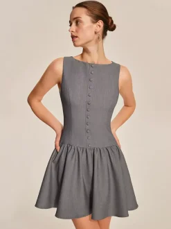 Mini-robe plissée sans manches et boutonnée sur le devant grise été 2026