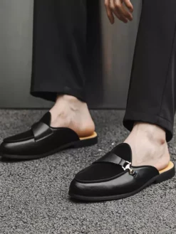 Mocassins noirs à bout rond avec détails métalliques et talon ouvert
