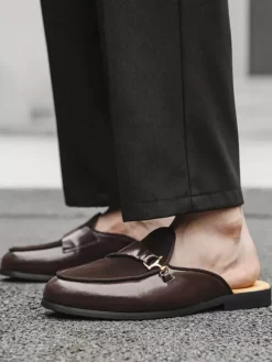 Mocassins noirs à bout rond avec détails métalliques et talon ouvert