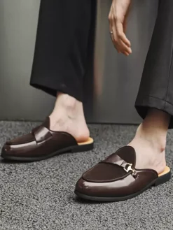 Mocassins noirs à bout rond avec détails métalliques et talon ouvert