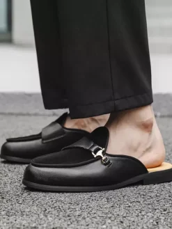 Mocassins noirs à bout rond avec détails métalliques et talon ouvert