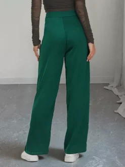 Pantalon de costume taille haute à double boutonnage et jambes larges coupe drapée.