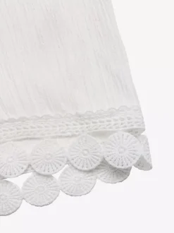 Pantalon large à ourlet en dentelle blanche et cordon de serrage coupe ample et décontractée idéal pour l'été.