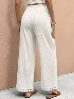 Pantalon large à ourlet en dentelle blanche et cordon de serrage coupe ample et décontractée idéal pour l'été.