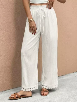 Pantalon large à ourlet en dentelle blanche et cordon de serrage coupe ample et décontractée idéal pour l'été.