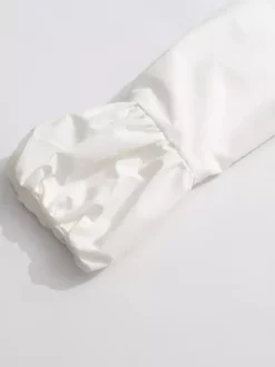 Robe courte blanche boutonnée à manches longues et col rabattu idéale pour tous les jours.
