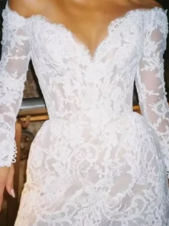 Robe de mariée courte à col en V et manches longues coupe trapèze.