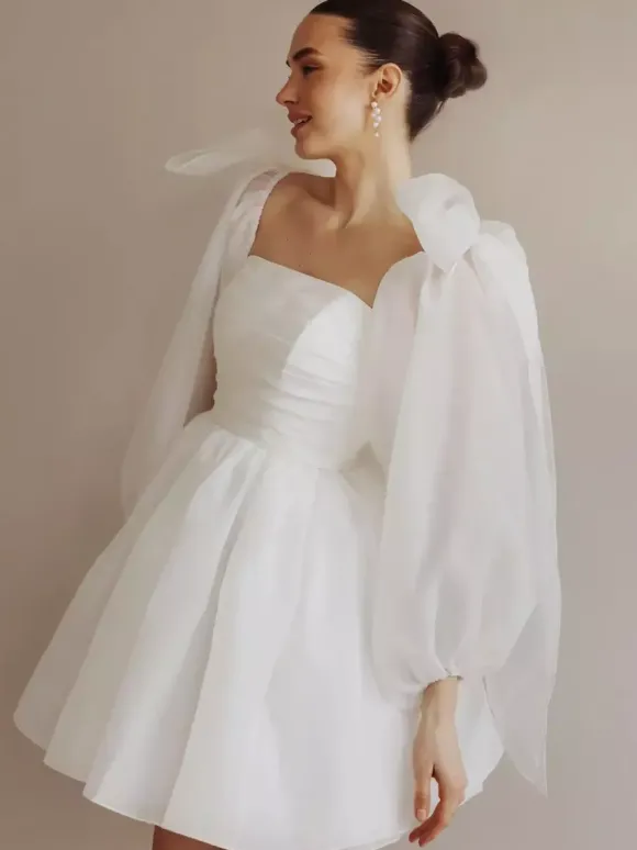 Robe de mariée courte bustier manches longues coupe princesse taille naturelle en organza