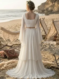 Robe de mariée deux pièces en mousseline décolleté travaillé coupe trapèze avec traîne manches longues