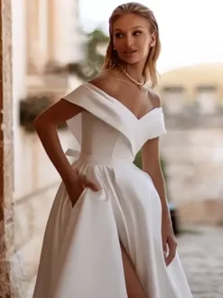 Robe de mariée vintage avec traîne épaules dénudées manches courtes fente sur le devant en satin.